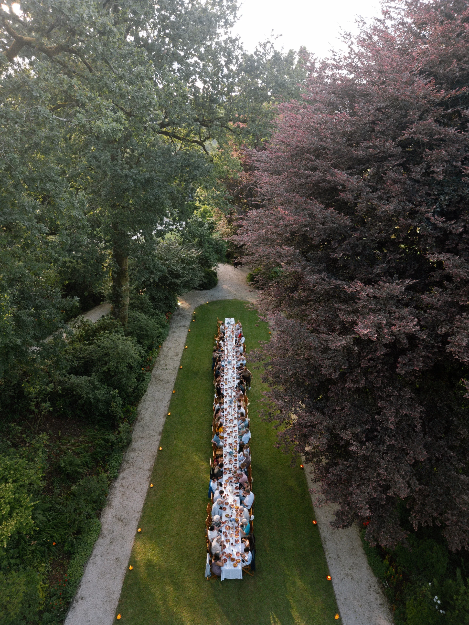 Aerial view of a long wedding dinner table surrounded by lush gardens at a destination wedding in Portugal